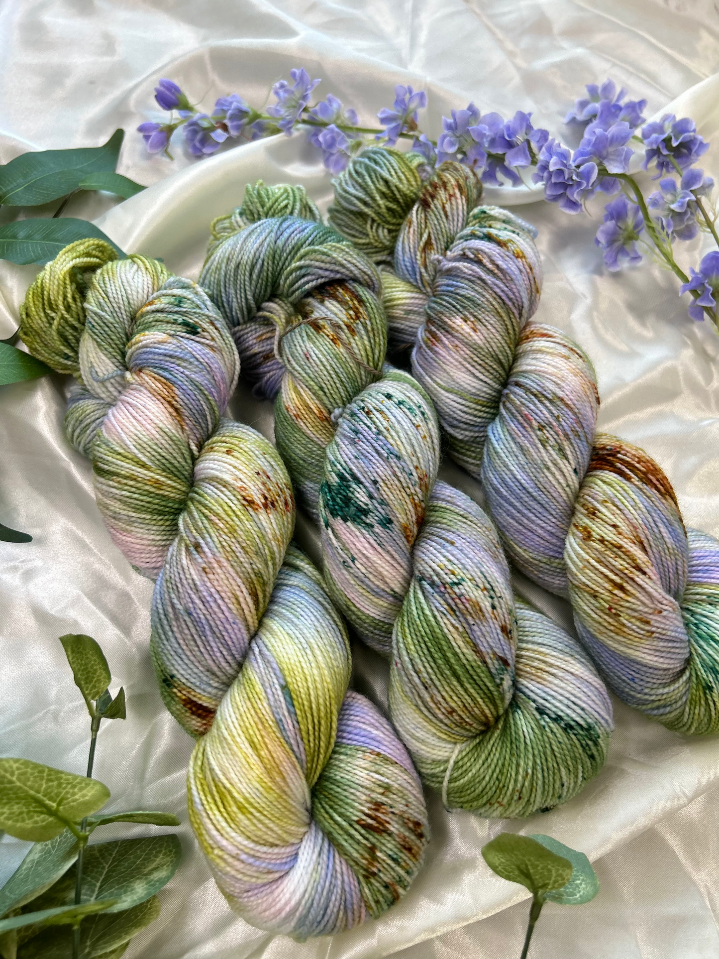custom lilac, green, dark green, gold variegated hand dyed yarn with forest green and fawn brown speckles on nylon superwash sock weight