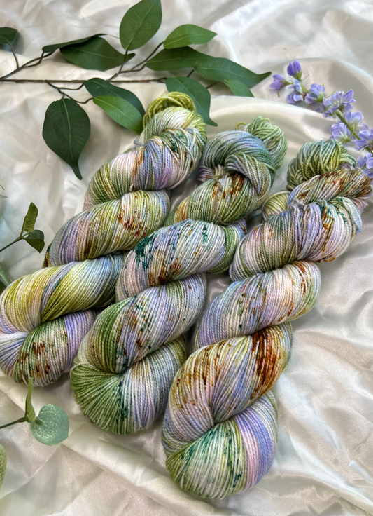 custom lilac, green, dark green, gold variegated hand dyed yarn with forest green and fawn brown speckles on nylon superwash sock weight