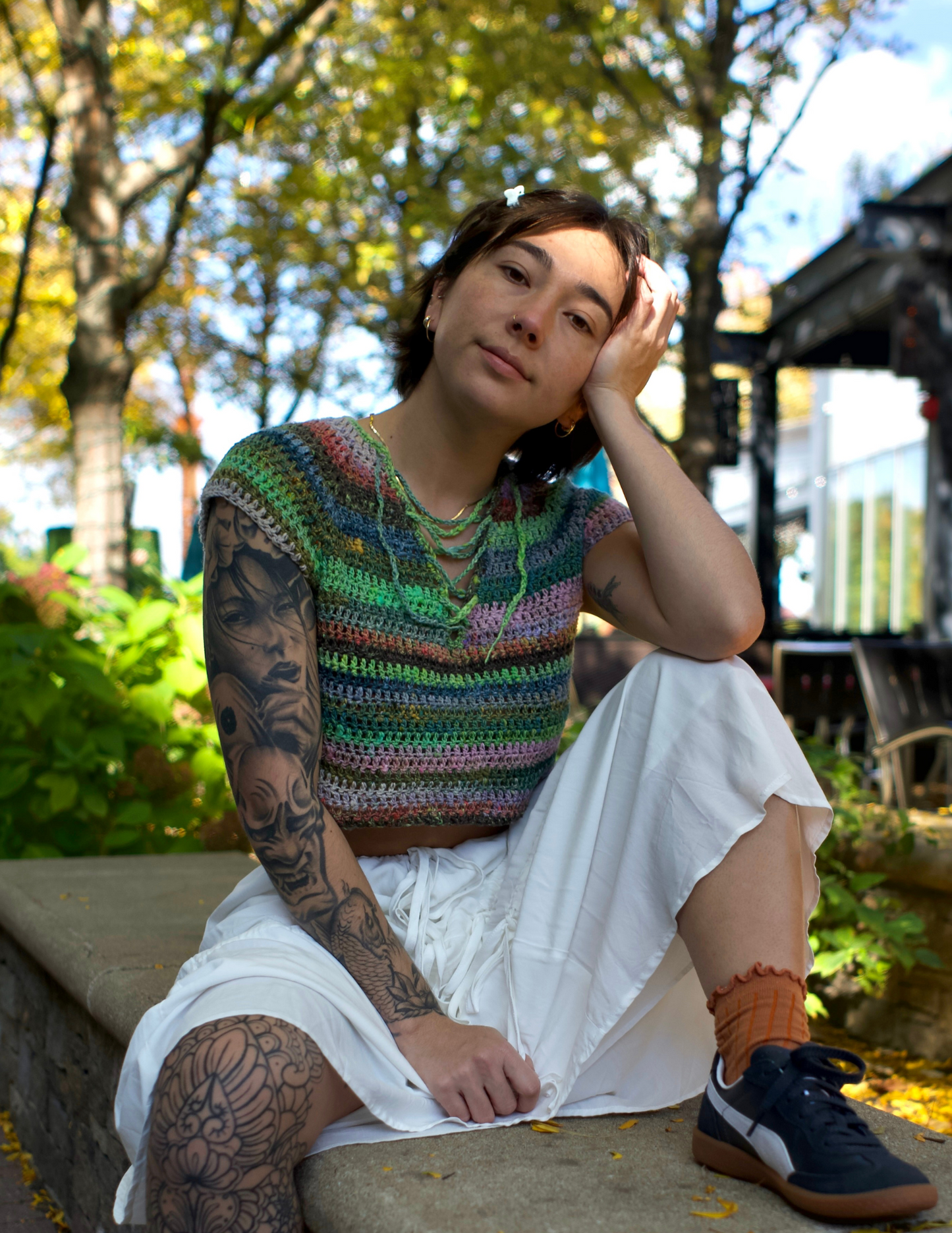 Erin wearing a colorful v-neck crochet top featuring a raglan design and laced center.