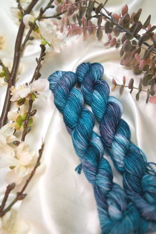 custom variegated hand dyed yarn with teal, deep blue and white on nylon superwash sock weight