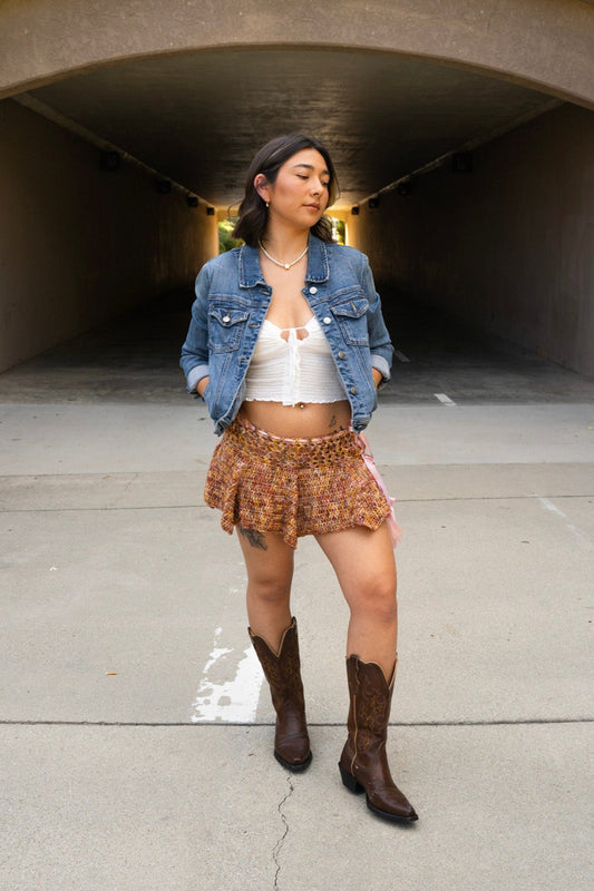 erin wearing a handmade crochet skirt that has a lace body band and wavy ruffles, made with variegated hand dyed yarn