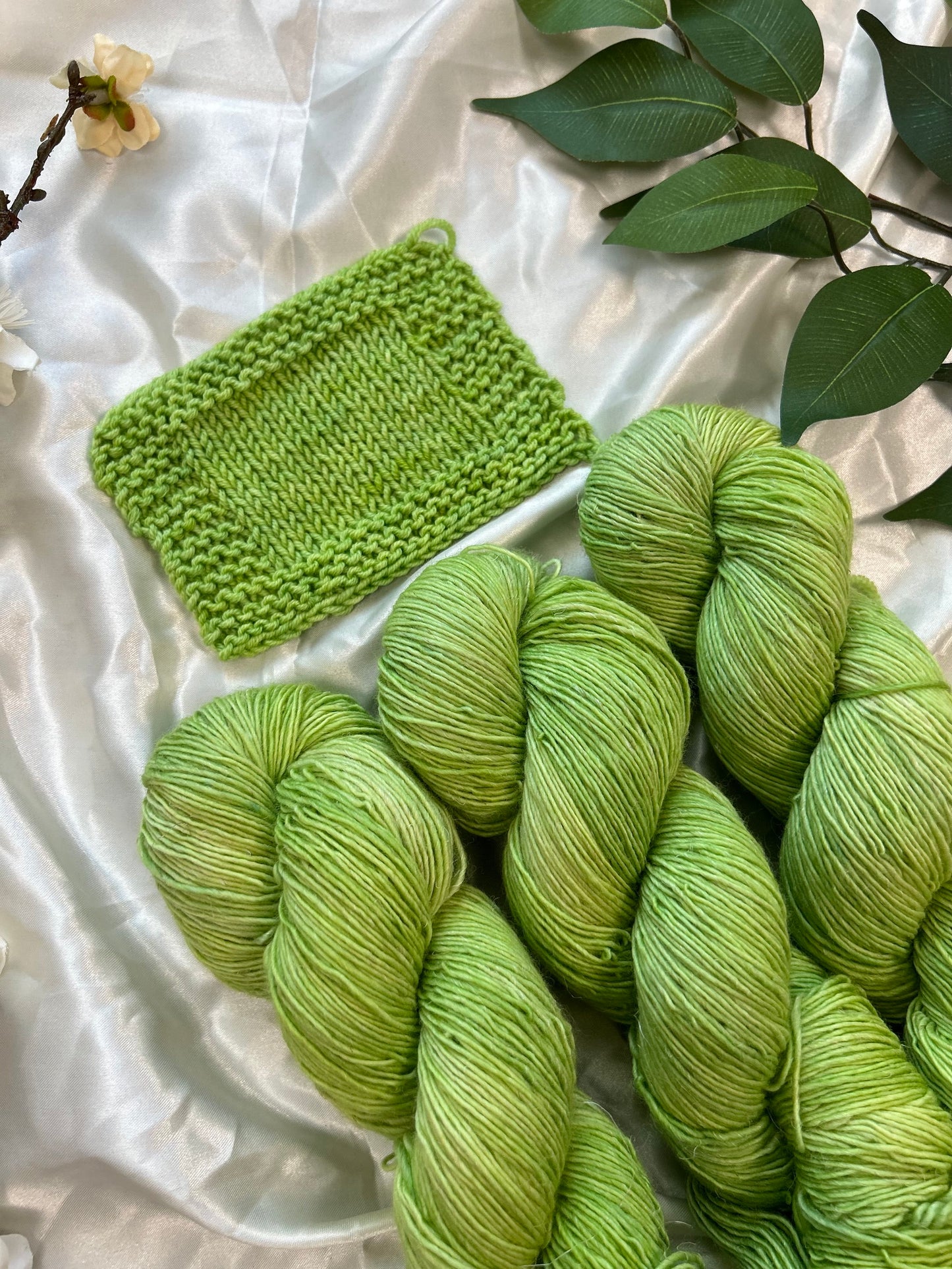 yellow toned green semi solid hand dyed yarn on linen sock fiber and swatch made on sw fingering