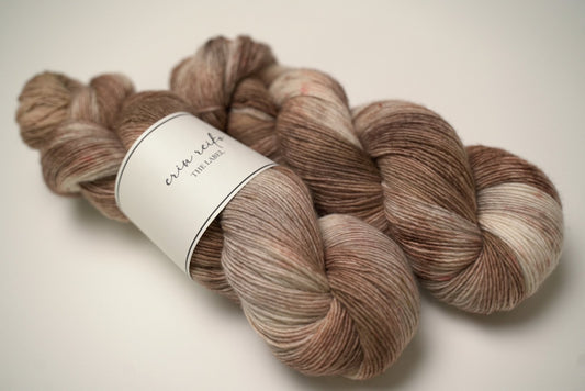 custom variegated hand dyed yarn with cream, brown and tan with light brown speckles on superwash merino fingering weight