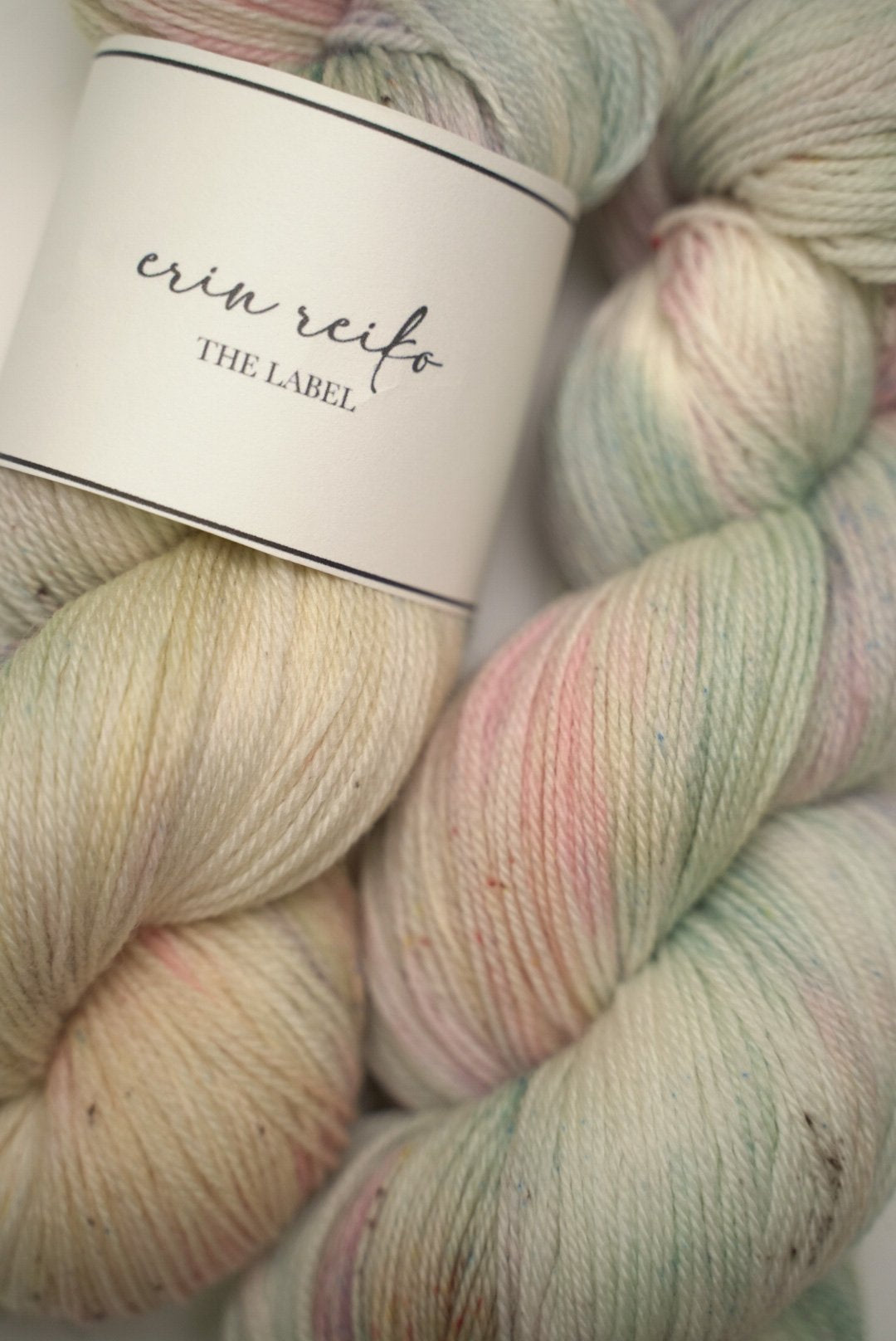 custom mint, sage green, flamingo pink, pastel yellow variegated hand dyed yarn with light cocoa brown speckles on superwash merino fingering weight
