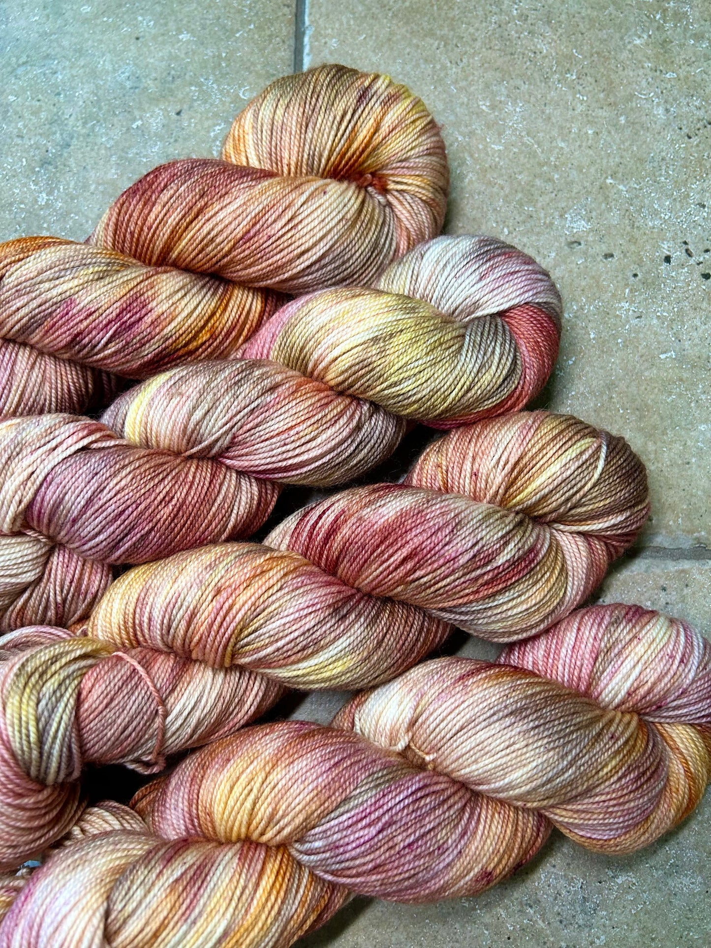 custom mauve, burgundy, gold and brown variegated hand dyed yarn on nylon superwash sock weight