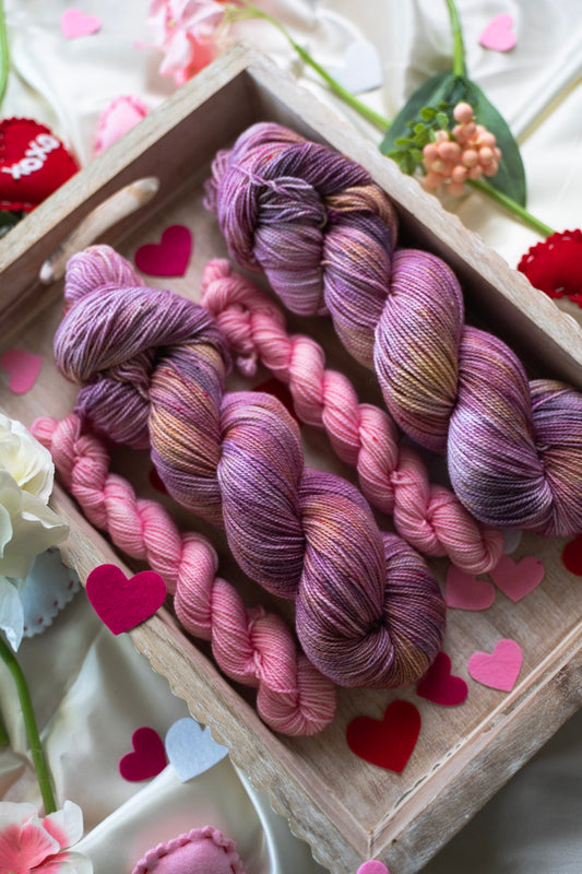 custom purple, mauve and pink variegated hand dyed yarn with gold and bright pink speckles on nylon superwash sock weight
