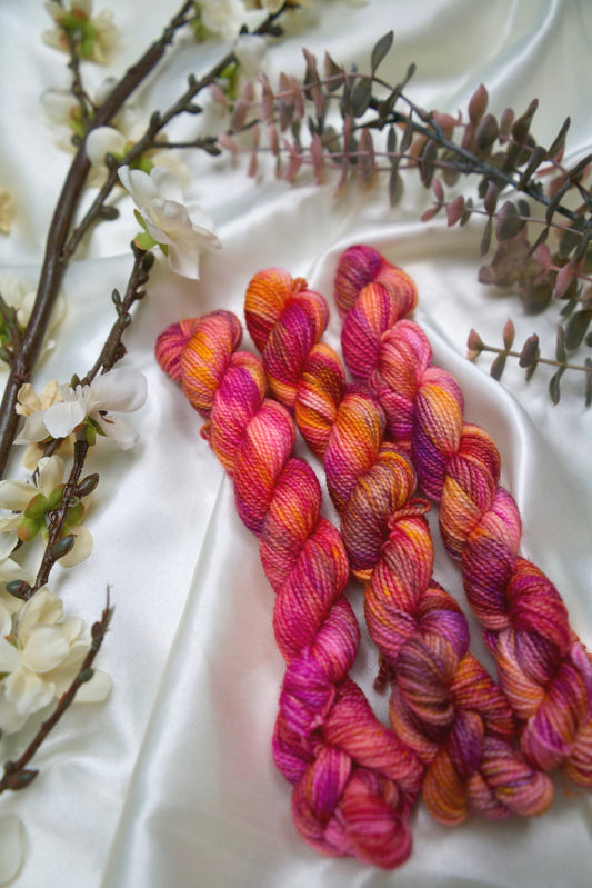 custom magenta, purple, orange, and
soft pink variegated hand dyed yarn on nylon superwash sock weight