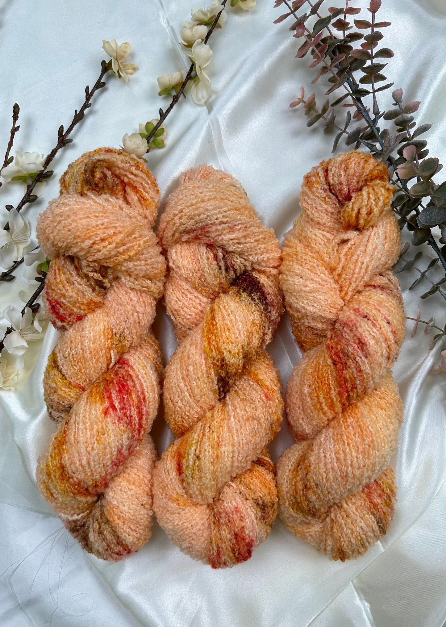 custom peach and cream orange variegated hand dyed yarn with brown, yellow and gold speckles on superwash merino boucle yarn