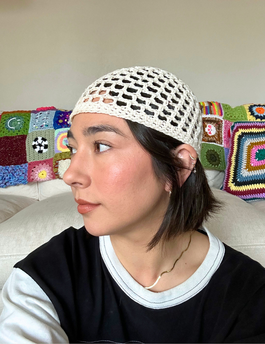 Erin wearing the meshi skull cap hat featuring an open mesh stitch and tight fit