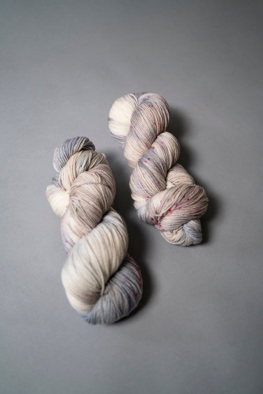 custom periwinkle, blue, purple, tan, beige variegated hand dyed yarn with hot pink speckles on superwash merino fingering weight