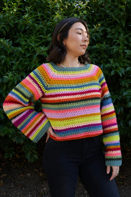 erin wearing a bright striped crochet sweater using a raglan top down design