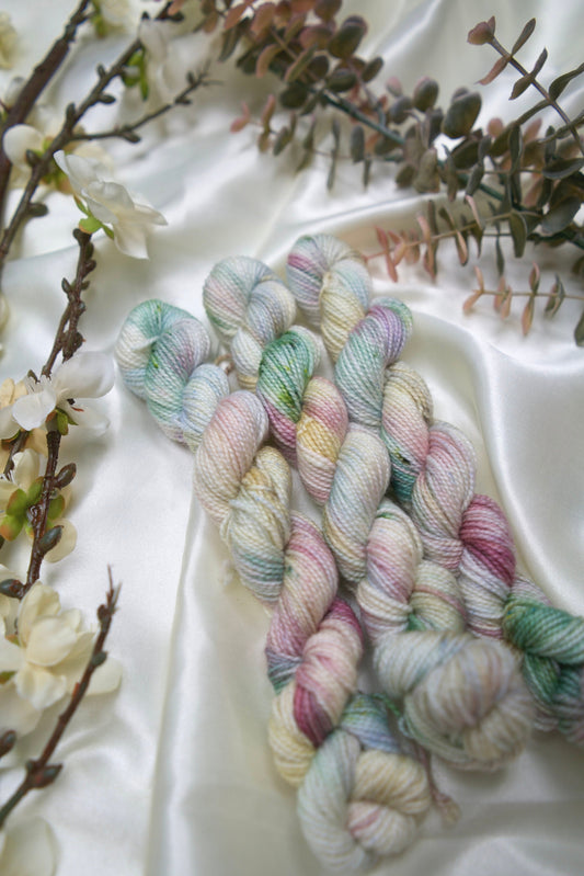 custom cream, pastel blue, green, burgundy, yellow variegated hand dyed yarn on nylon superwash nylon sock weight
