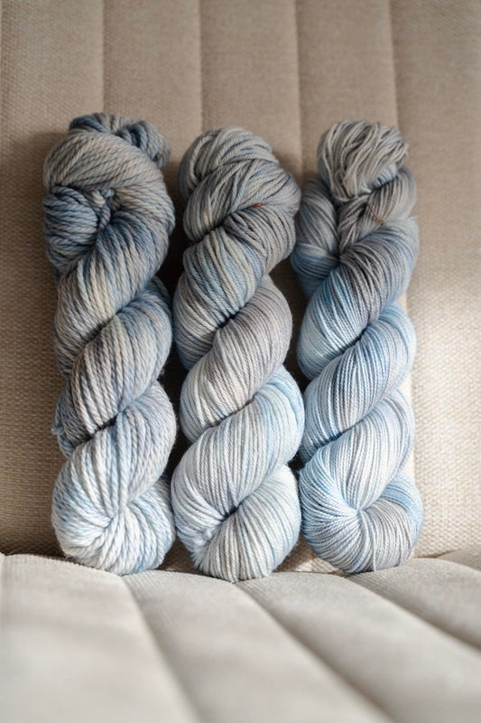 custom light blue, bright blue, soft tan, grey variegated hand dyed yarn on nylon superwash merino sock weight
