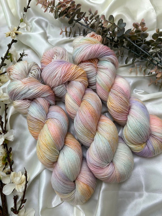 custom pastel pink, lilac, orange, sky blue variegated hand dyed yarn on superwash merino fingering weight