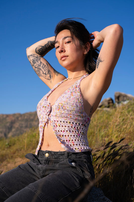 erin wearing a lilac colored crochet halter top, featuring triangle cups, mesh detailing and a crochet flower