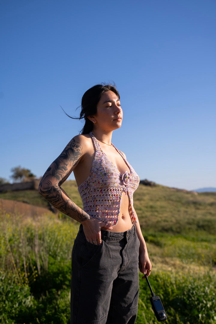 erin wearing a lilac colored crochet halter top, featuring triangle cups, mesh detailing and a crochet flower