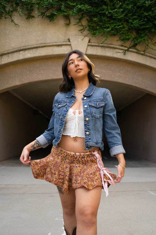 erin wearing a handmade crochet skirt that has a lace body band and wavy ruffles, made with variegated hand dyed yarn