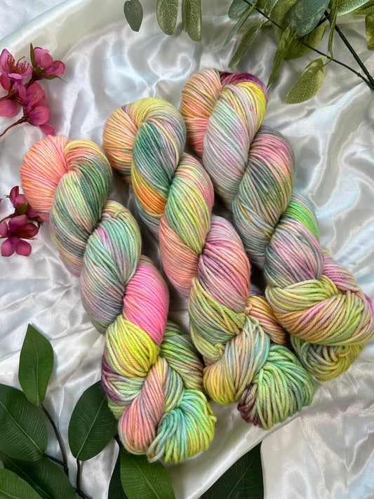 custom pastel rainbow hand dyed yarn with neon pinks, blues, teals and yellow on  superwash merino dk weight