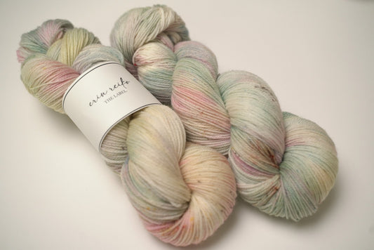 custom mint, sage green, flamingo pink, pastel yellow variegated hand dyed yarn with light cocoa brown speckles on superwash merino fingering weight