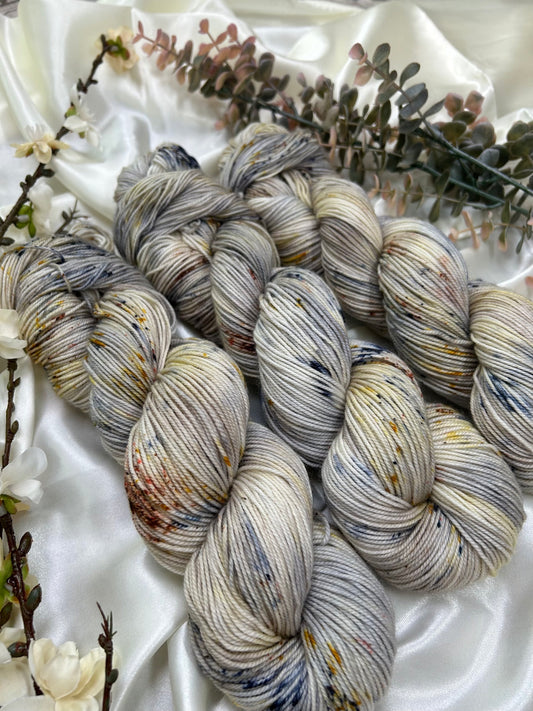 custom navy blue, grey, sepia variegated hand dyed yarn with gold, yellow and cocoa brown speckles on superwash nylon sock weight