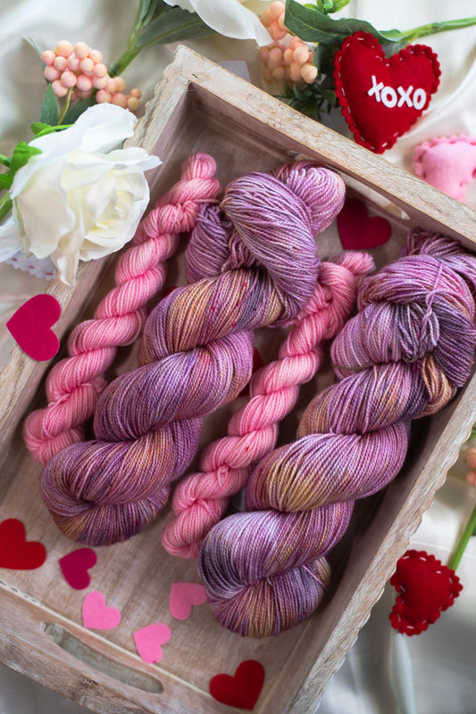 custom purple, mauve and pink variegated hand dyed yarn with gold and bright pink speckles on nylon superwash sock weight