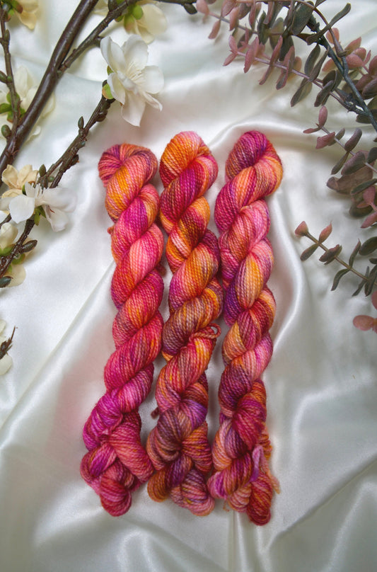 custom magenta, purple, orange, and 
soft pink variegated hand dyed yarn on nylon superwash sock weight