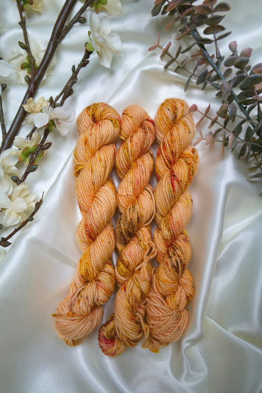 custom peach and cream orange variegated hand dyed yarn with brown, yellow and gold speckles on nylon superwash sock weight
