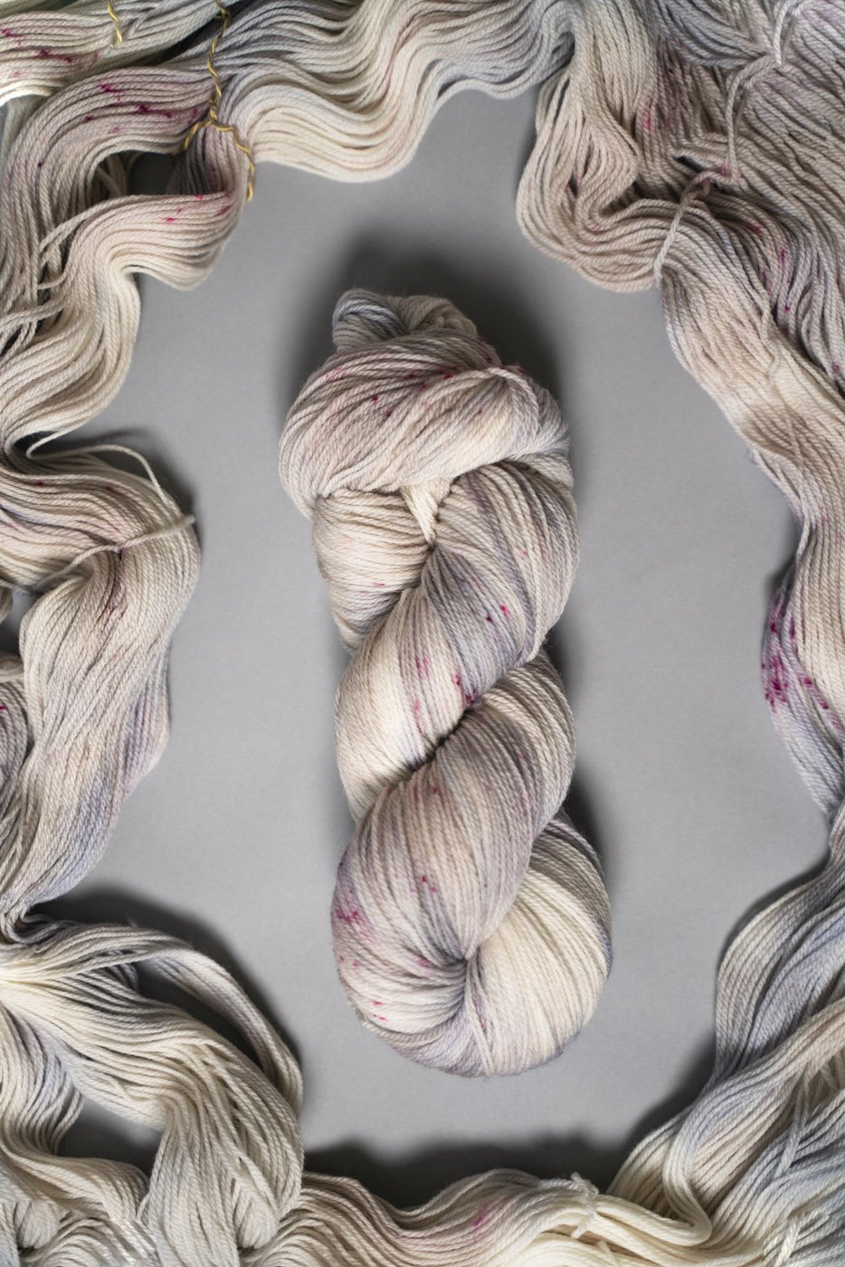 custom periwinkle, blue, purple, tan, beige variegated hand dyed yarn with hot pink speckles on superwash merino fingering weight