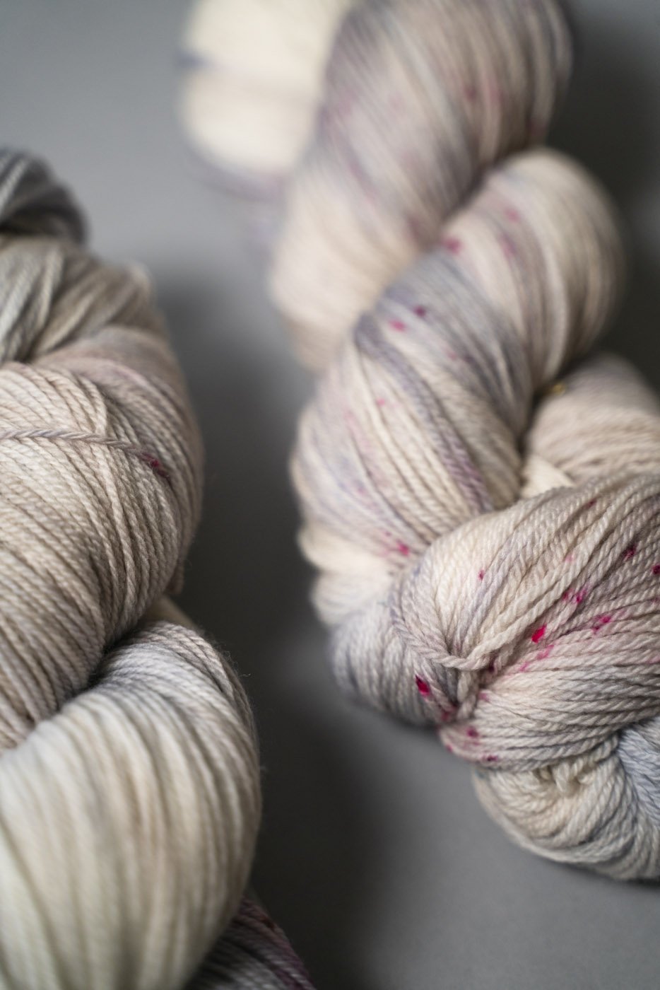 custom periwinkle, blue, purple, tan, beige variegated hand dyed yarn with hot pink speckles on superwash merino fingering weight