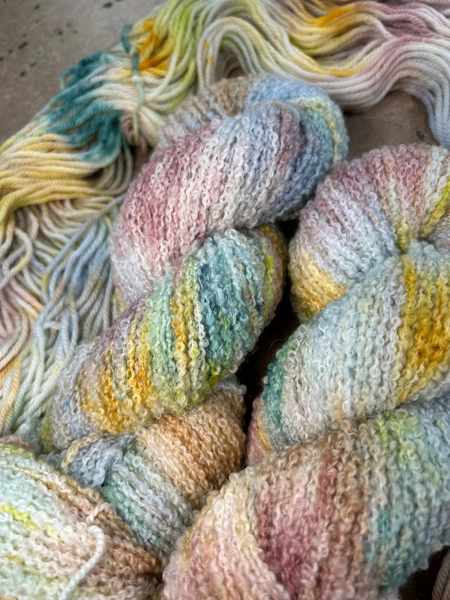 custom steel blue, cream, mauve, gold, hazel brown and lime green variegated hand dyed yarn with teal on superwash boucle yarn