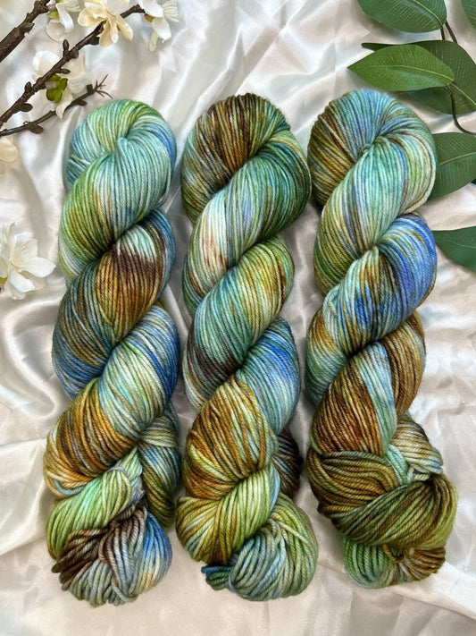 custom bright blue, green, cornflower blue, tan, brown variegated hand dyed yarn on superwash merino dk weight