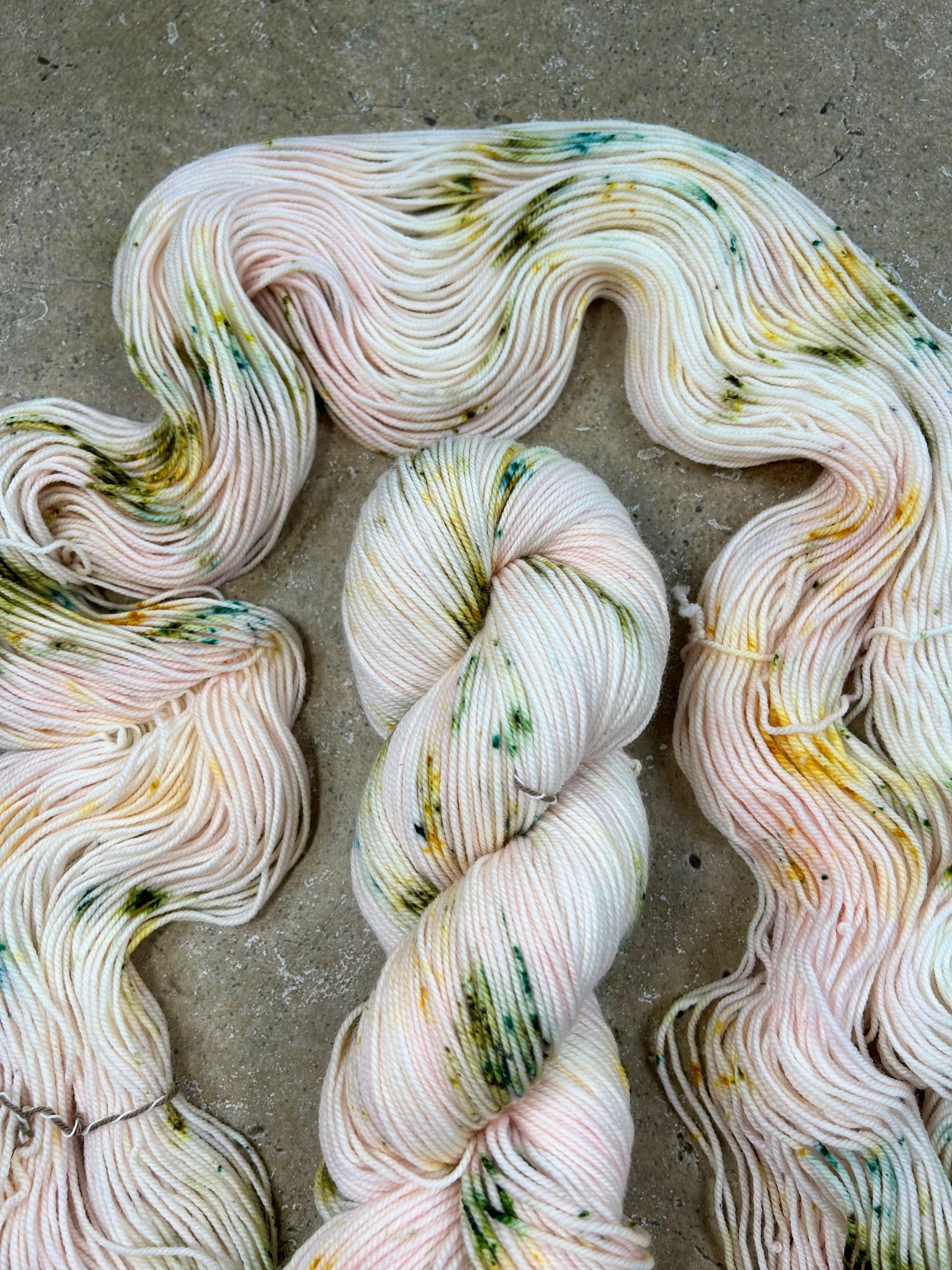 custom pastel baby pink variegated hand dyed yarn with forest green and gold speckles on nylon superwash merino sock 