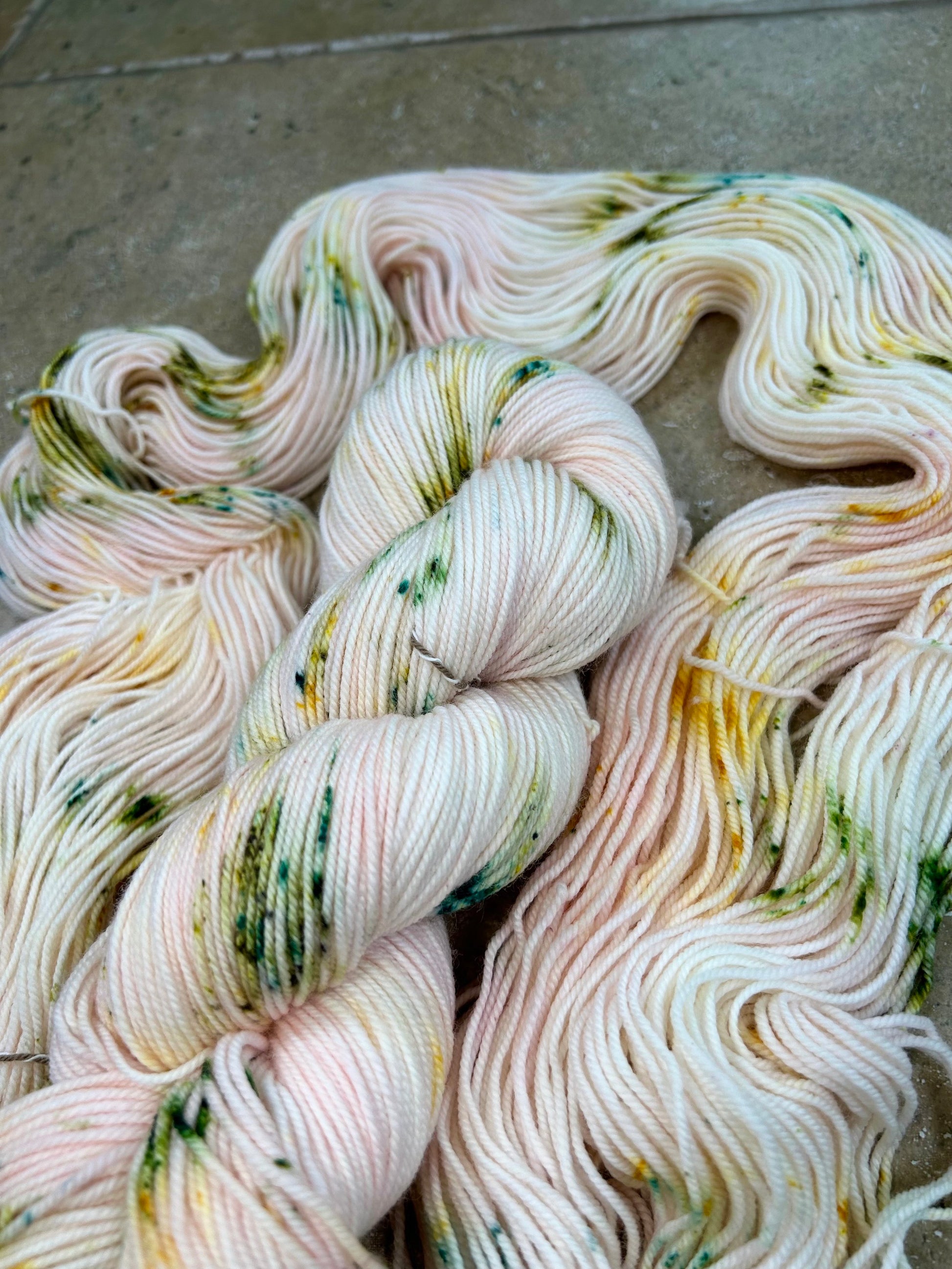 custom pastel baby pink variegated hand dyed yarn with forest green and gold speckles on nylon superwash merino sock 