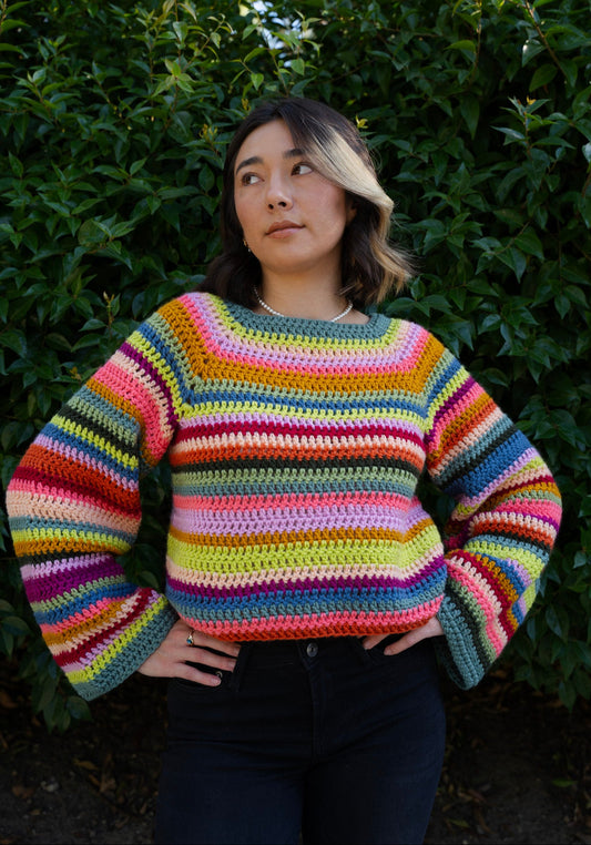erin wearing a bright striped crochet sweater using a raglan top down design