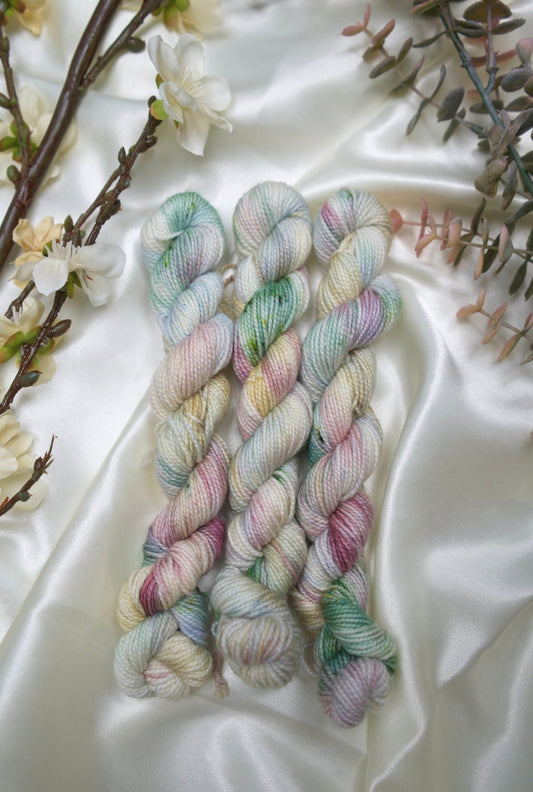 custom cream, pastel blue, green, burgundy, yellow variegated hand dyed yarn on nylon superwash nylon sock weight