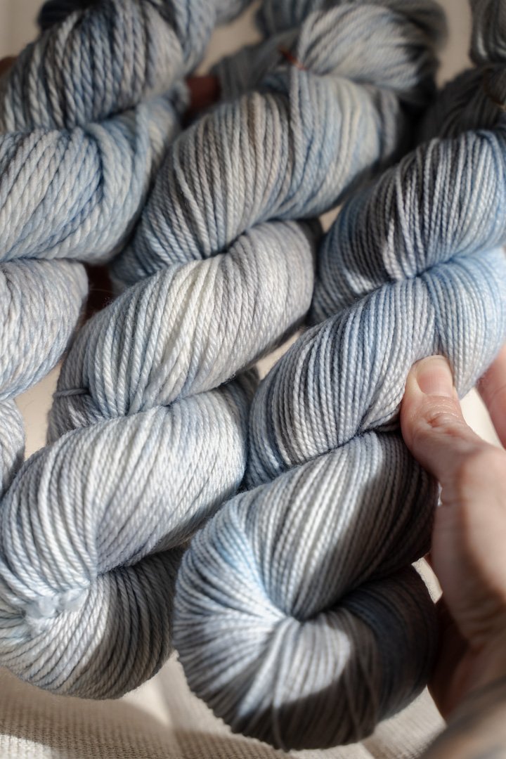 custom light blue, bright blue, soft tan, grey variegated hand dyed yarn on nylon superwash merino sock weight
