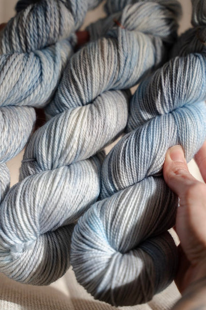custom light blue, bright blue, soft tan, grey variegated hand dyed yarn on nylon superwash merino sock weight