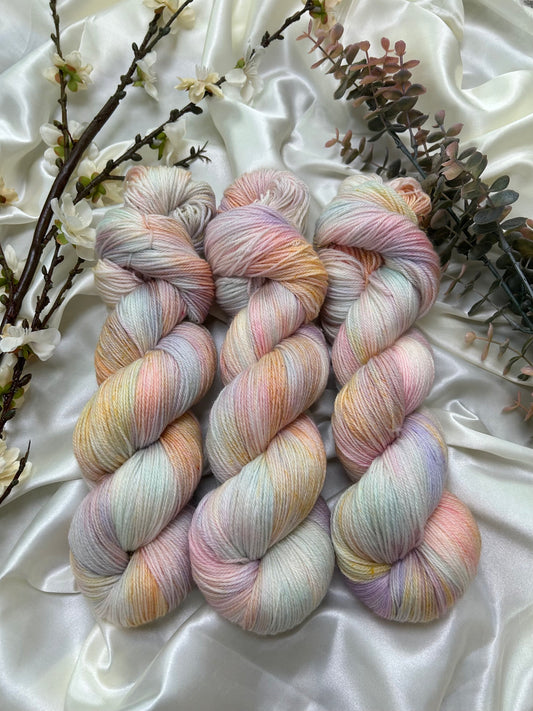 custom pastel pink, lilac, orange, sky blue variegated hand dyed yarn on superwash merino fingering weight