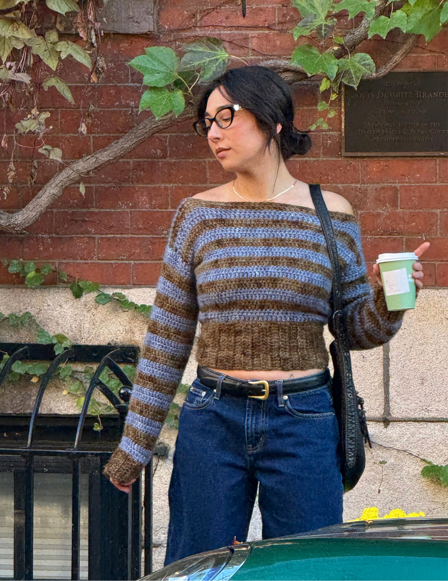 woman wearing long sleeve striped slouchy blouse crochet top, holding coffee