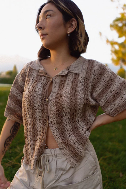 erin wearing a striped crochet top that is buttoned at center and has a delicate lace pattern and notched collar
