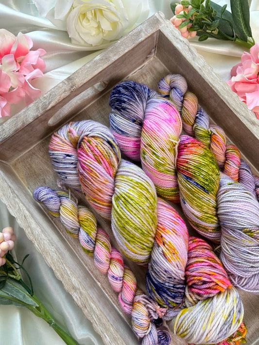 custom lilac and purple variegated hand dyed yarn with bright pink, lime green speckles on nylon superwash sock weight and dk weight